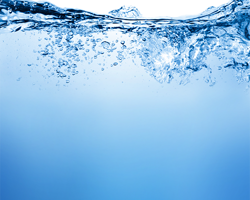 Side view of blue water filling up most of the image. The water is disturbed on top, with bubbles and a small splash