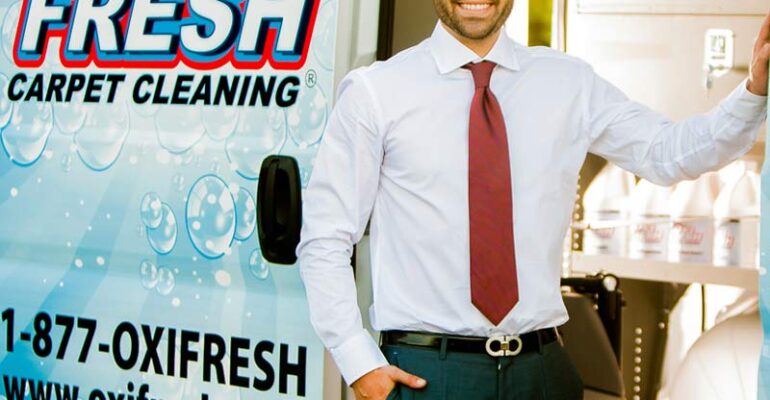 Jonathan Barnett standing in front of an Oxi Fresh vehicle with products inside the vehicle.