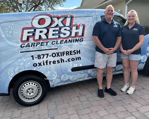 This photo shows Will Chambers and his partner standing in front of an Oxi Fresh van.