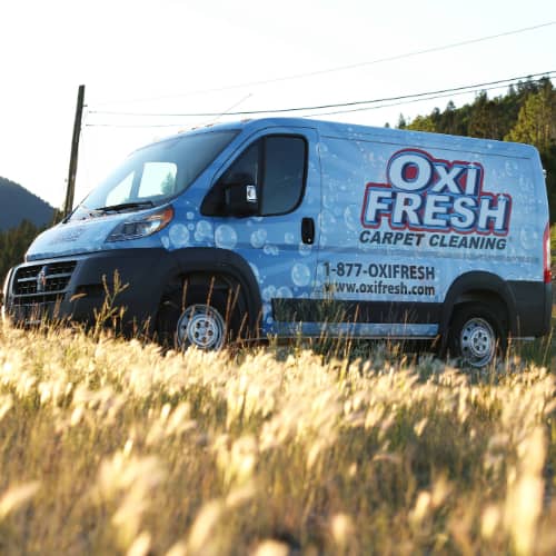 Oxi Fresh van parked by a prairie.